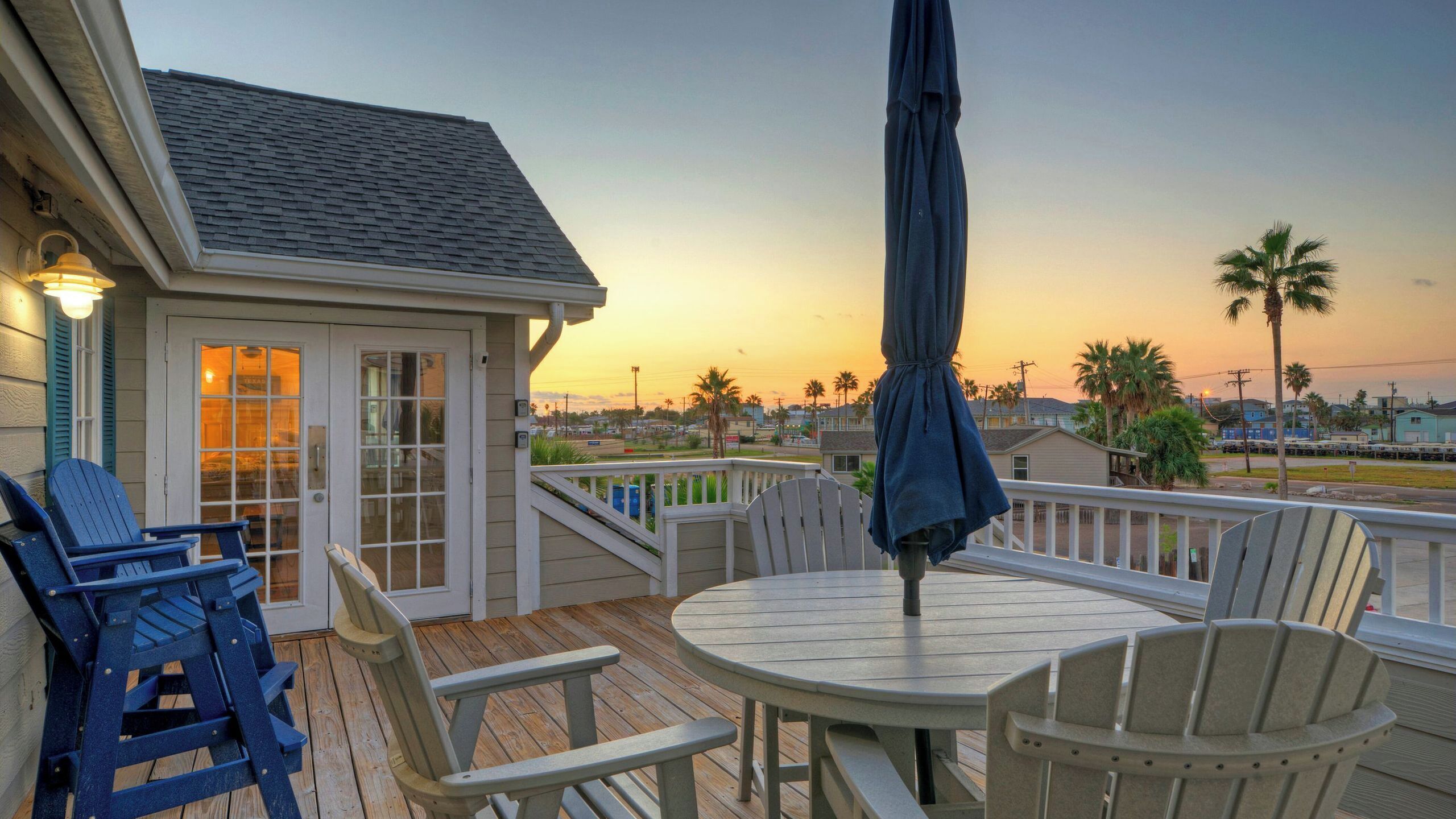 A deck with chairs, a table, and an umbrella.