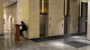 Un'elegante hall moderna con pavimento in marmo, un podio e ascensori.