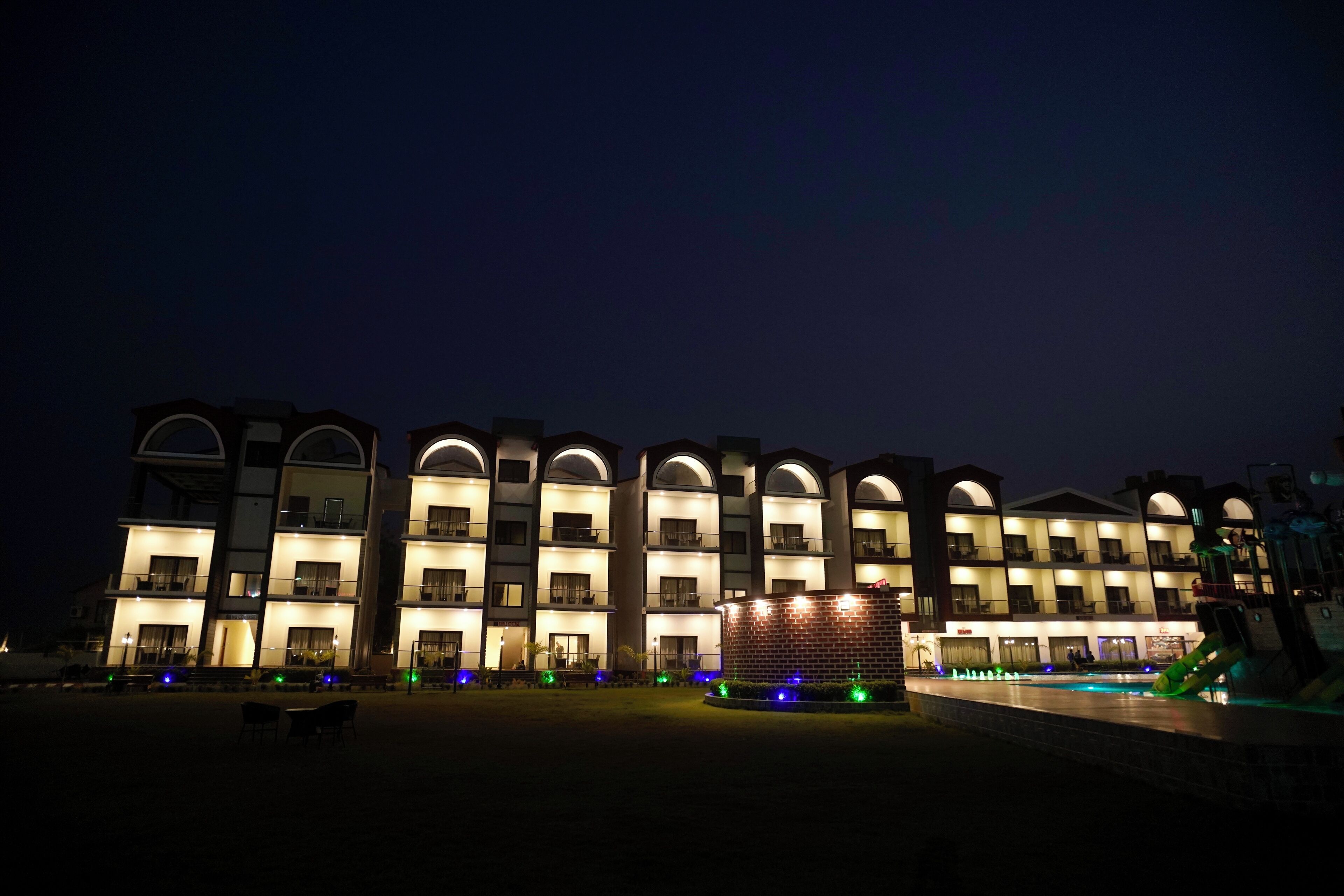 A multi-story hotel with arched balconies and a central courtyard with a water feature.