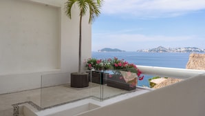 A balcony with a palm tree, potted plants, and a view of the sea. - Villa Majum Ocean View Acapulco 5 BDR (Acapulco)