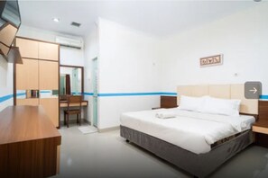 A hotel room with a bed, a desk, a chair, and a wardrobe. - Tebet Utara Suites (Jakarta)