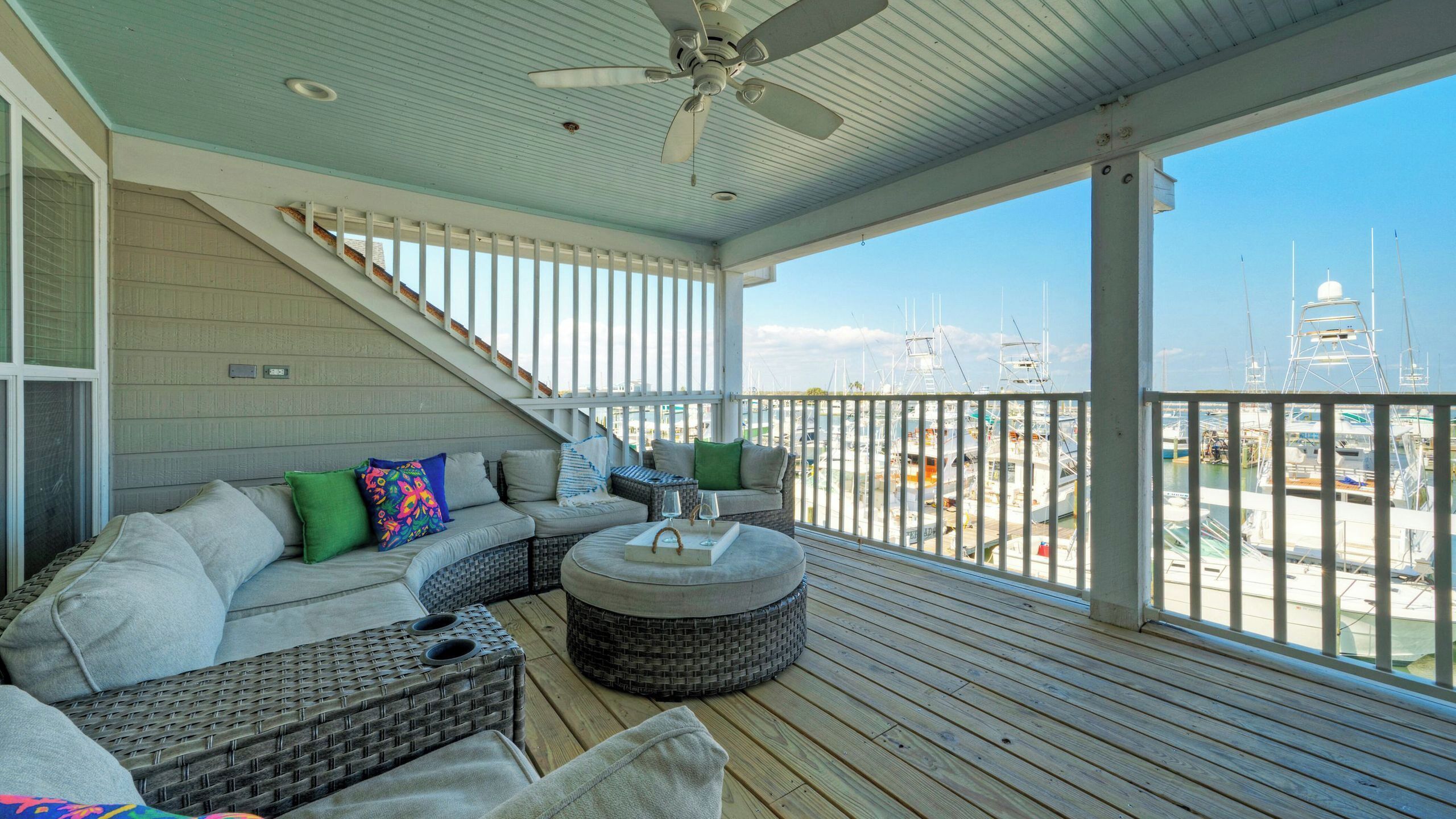 A covered outdoor seating area with a view of a marina.