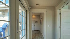 A hallway with a wooden floor leading to a door marked with the number 3. - Dolphin at Trout Street Queen Suite w/ Kitchenette Marina-front + Patio (Port Aransas)