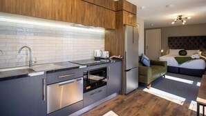 Een moderne keuken met roestvrijstalen apparatuur, houten kastjes en een inbouwoven.