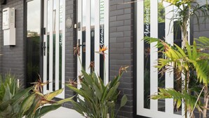 A building facade with three doors labeled "Apartment Three" and "Apartment Four." - The Residence Apartment Three (New Plymouth)