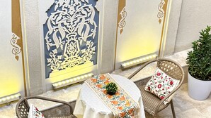 A dining area with wicker chairs and a table covered with a floral tablecloth. - Daro Hotel (Bukhara)