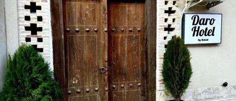 A wooden double door with a sign reading "Daro Hotel" above it.