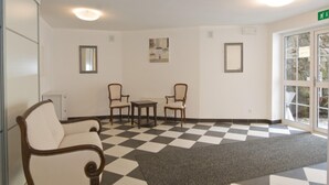 A room with a checkered floor, two armchairs, a small table, and a radiator. - Apartment Bad Gastein Near Ski Lifts (Bad Gastein)