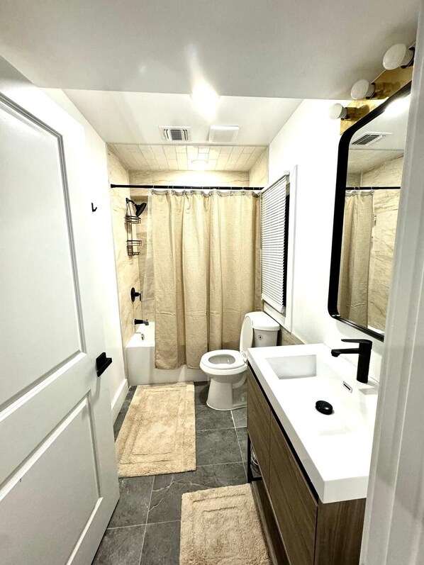 Un baño moderno con inodoro, lavabo y ducha.