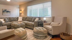 Una sala de estar con un sofá modular, una chaise lounge y dos otomanas.