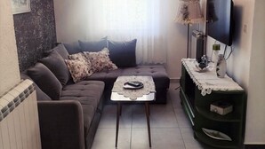 A living room with a sofa, a coffee table, a TV, and a lamp. - Spacious Novi Vinodolski Apartments With Terrace and Shared Pool (Novi Vinodolski)