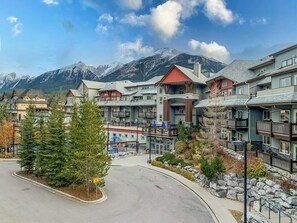 A resort with multiple buildings, a parking area, and a mountain backdrop.