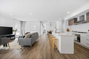 A modern living room with a grey sofa, a flat-screen TV, and a wooden coffee table. - Bellamama's @ Ballarat (Winter Valley)