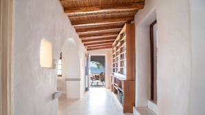 Ein Korridor mit Holzboden, weißen Wänden und einem Bücherregal.