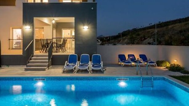 A modern building with a swimming pool, outdoor seating, and a staircase leading to the entrance. - Modern & Stylish Villa with Private Pool - Four Bedroom Villa with Pool (Tugare)