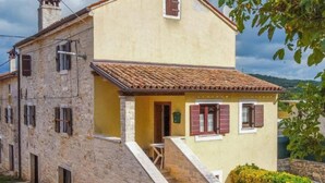 A two-story house with a stone facade, a tiled roof, and a small porch with a staircase leading to the entrance. - Villa Adriana - Two Bedroom Villa (Bale)