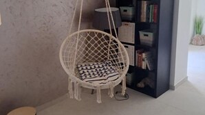 A room with a macramé hanging chair, a bookshelf, and a lamp. - Villa Adriana - Two Bedroom Villa (Bale)