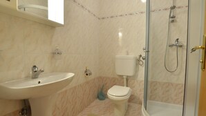Ein Badezimmer mit Waschbecken, Toilette und Duschkabine.