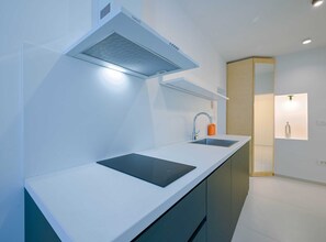 Enjoy cooking in this well-equipped kitchen with a range hood, stainless steel sink, and ample countertop space.