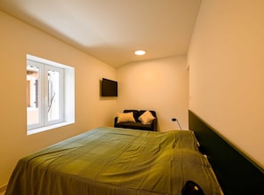 Cozy retreat with a single bed, flat-screen TV, and simple design.