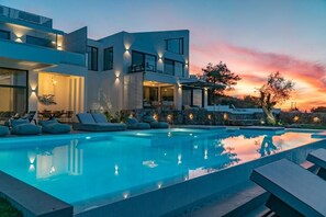 A modern two-story house with a swimming pool, outdoor seating, and a sunset view. - Superior Villa
 (Lefkada)