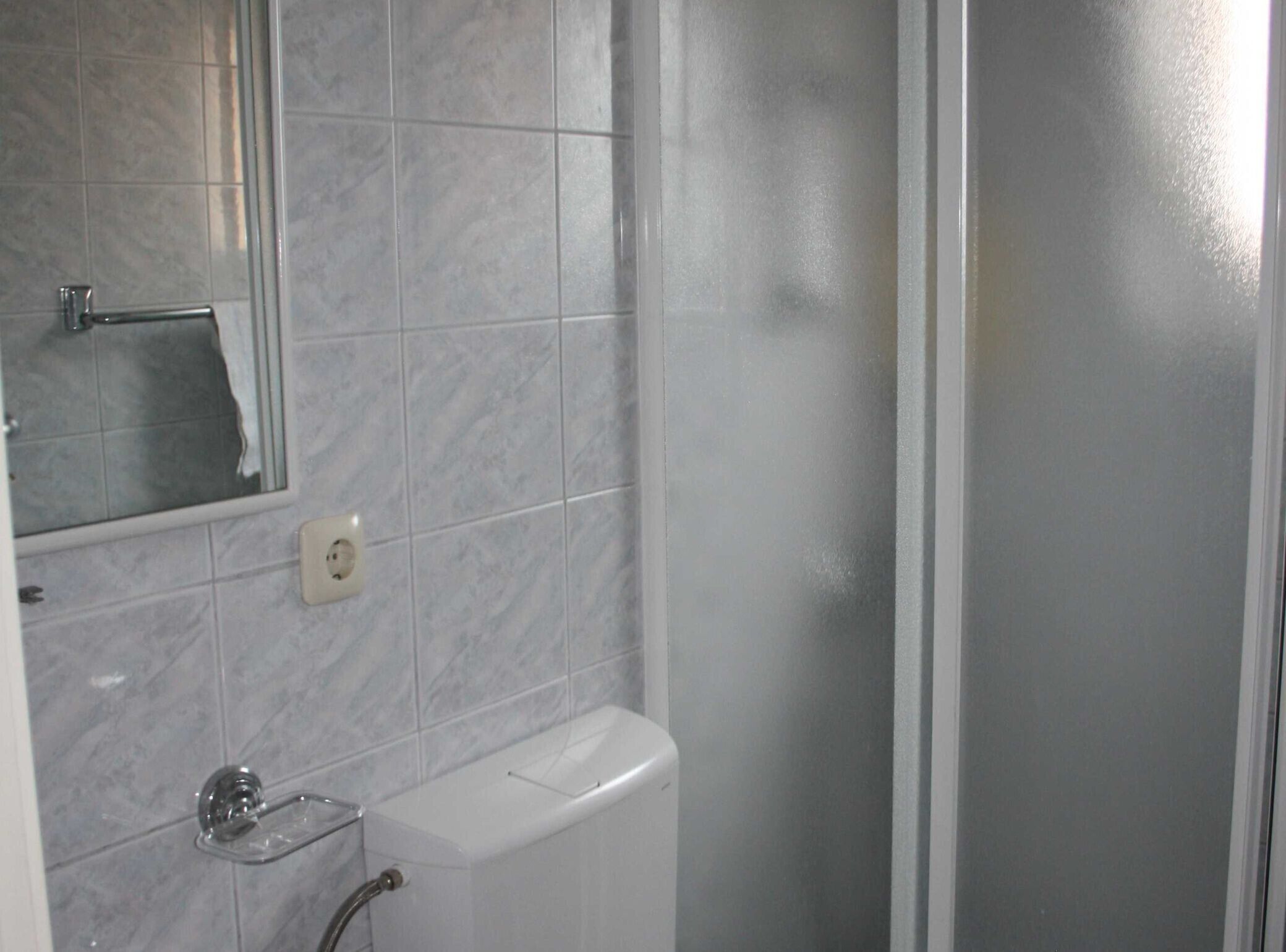 A bathroom with a toilet, a sink, and a mirror.
