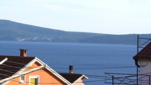 A coastal view with a house featuring a sloped roof and solar panels. - Sweet and Simple Sea view Crikvenica Apartments - One Bedroom Apartment withe Sea view and Balcony (Crikvenica)