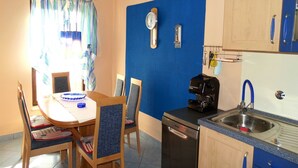 A compact kitchen with a sink, coffee maker, and clock on the wall. - Two Bedroom Apartment with Sea View and Balcony (Crikvenica)