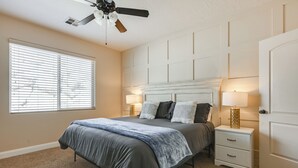 A bedroom with a bed, nightstands, a ceiling fan, and a window with blinds. - Home w/ Game Room: Near Zion National Park! (Hurricane)