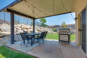 Une terrasse extérieure équipée d’un barbecue, d’une table à manger et de chaises.
