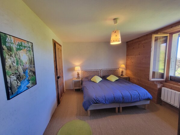 A bedroom with a bed, two bedside lamps, a poster on the wall, and a window. - La Grange (Chainaz-les-Frasses)