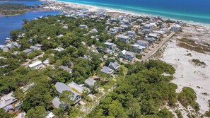 An aerial view of a coastal residential area with houses, dense greenery, and a beach. - As You Like It by Avantstay Steps to Beach, Bikes, Sleeps 18! (Santa Rosa Beach)