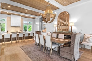 A modern kitchen with a dining area, wooden ceiling, and large windows. - 30A Beach Bliss by Avantstay Golf Cart + Luxury Private Pool (Santa Rosa Beach)