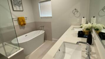 Une salle de bain moderne avec une baignoire, un lavabo et un espace douche.