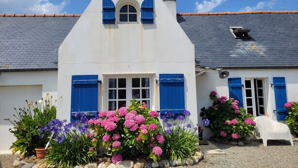 A white building with blue shutters and a triangular roof. - Tipoz'Immo • Maison Bleue Walking distance to the beach • Surf spot • garden (Pouldreuzic)