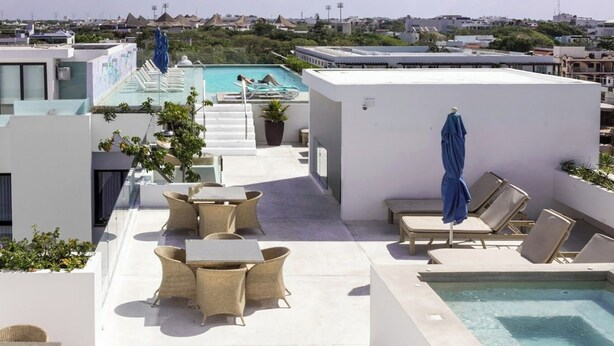 A rooftop pool area with lounge chairs, a small table, and a statue. - Amazing 2 floor penthouse w/PRIVATE rooftop (Playa del Carmen)