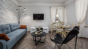 Een moderne woonkamer met een bank, salontafel en een eethoek.