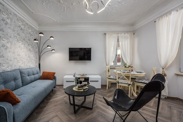 Un salon moderne avec un canapé, une table basse et un coin repas.