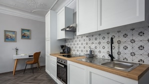Een moderne keuken met witte kasten, een houten aanrecht, een roestvrijstalen spoelbak en een inbouwoven.