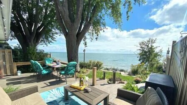 Un'area patio con mobili da esterno, una piscina e vista sul mare.