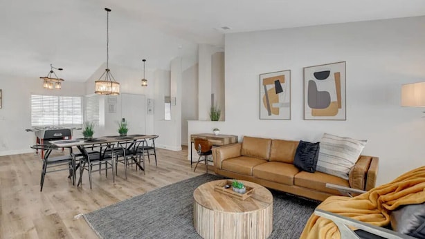 A spacious living area with a dining table, a sofa, and a coffee table. - 4BR Family Getaway w/Pool (North Las Vegas)