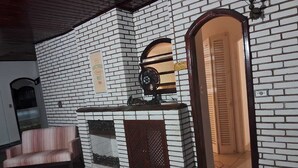 Een kamer met een bakstenen muur, een houten deur, een klein tafeltje en een stoel.