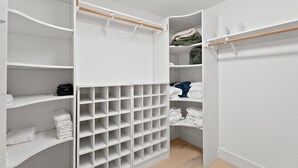 A walk-in closet with multiple shelves and hanging space, organized for storage. - Walkable Downtown Spa Retreat (Bend)