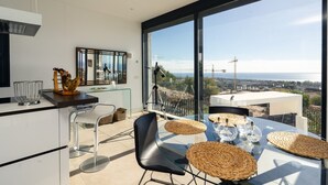 A modern kitchen with a glass dining table, chairs, and a view of the city. - Lavish Villa With Private Pool (Marbella)