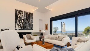 A modern living room with a white sofa set, a coffee table, and a large abstract painting. - Lavish Villa With Private Pool (Marbella)