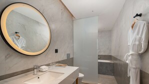 A modern bathroom with a large mirror, a sink, and a shower area. - Hilton Garden Inn Danzhou Yangpu (Danzhou)