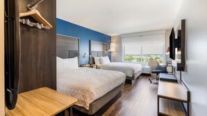 A hotel room with two beds, a desk, a chair, a TV, and a large window with a view. - Tru By Hilton Madison East (Madison)