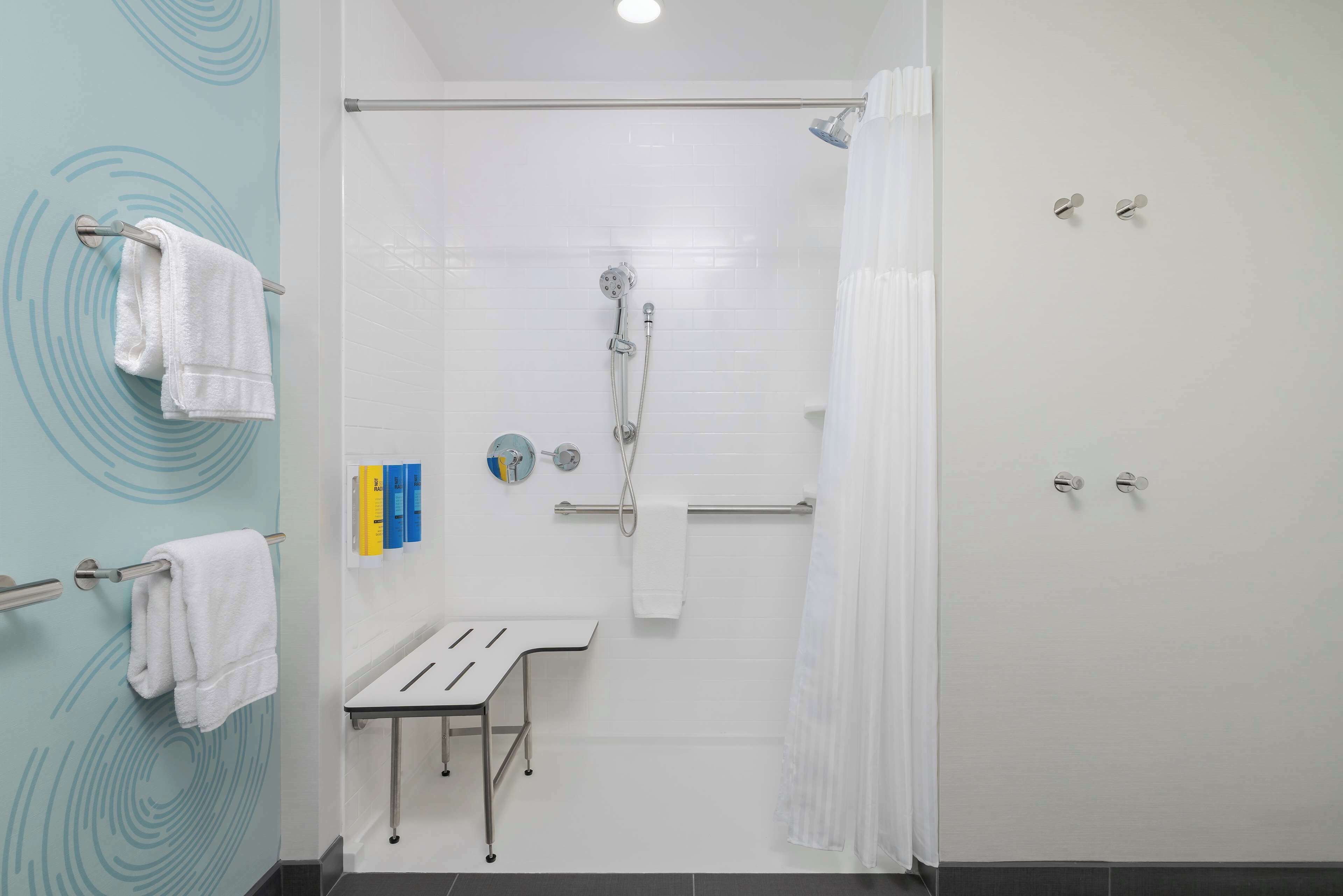 A modern bathroom with a shower, toilet, and sink.