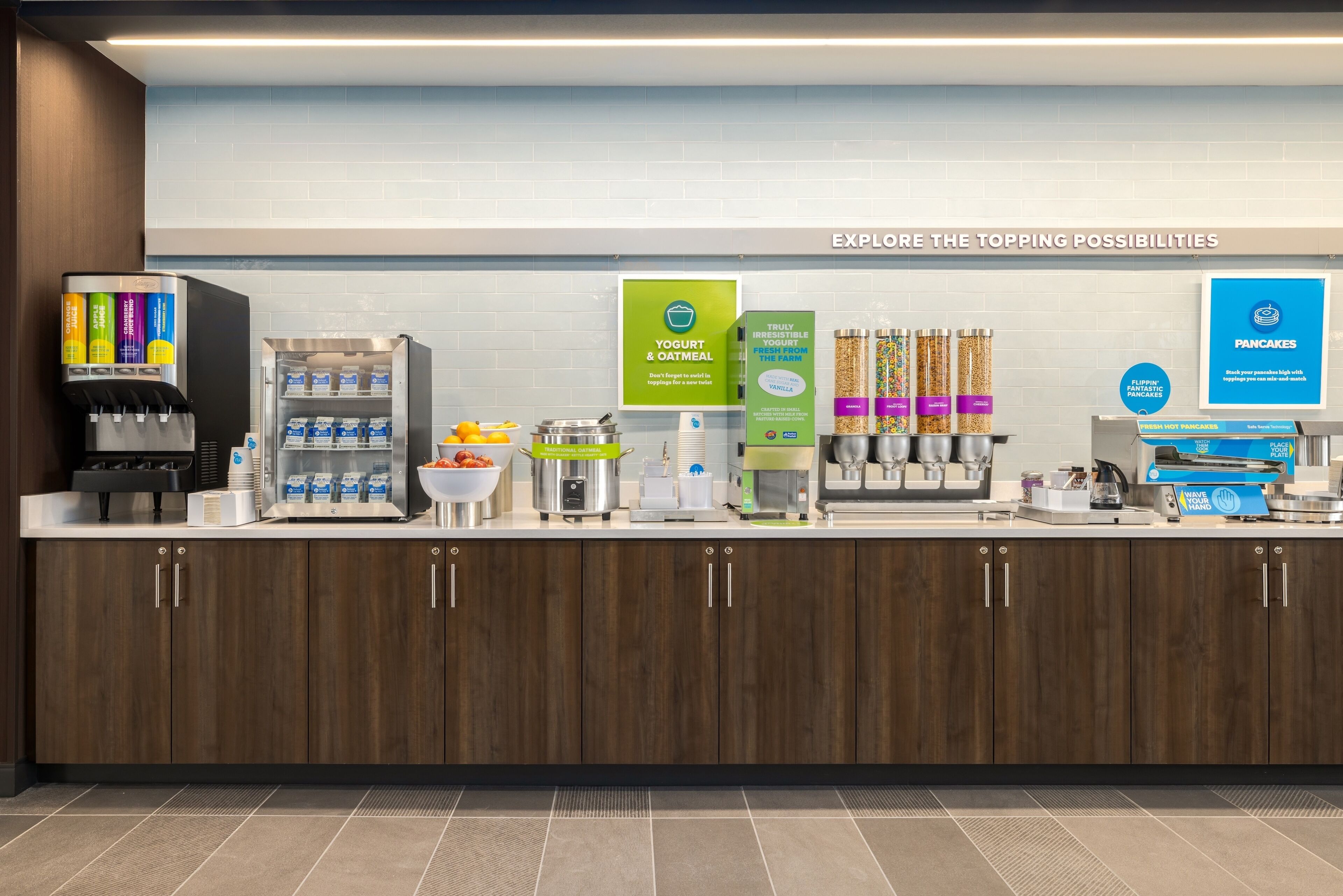 Een ontbijtbuffet met yoghurt, havermout, pannenkoeken en diverse toppings.