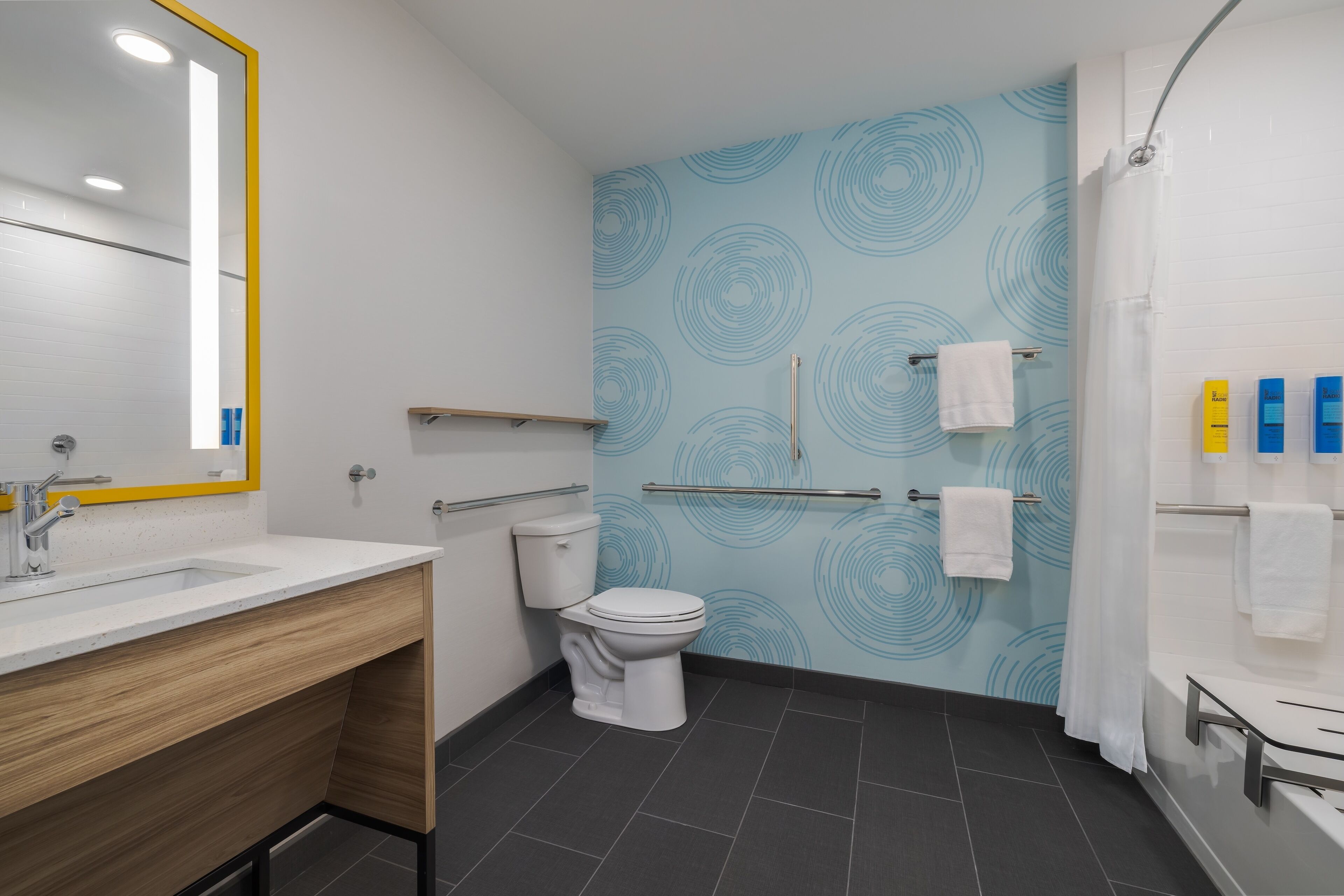 A modern bathroom with a white sink, a toilet, and a shower area.